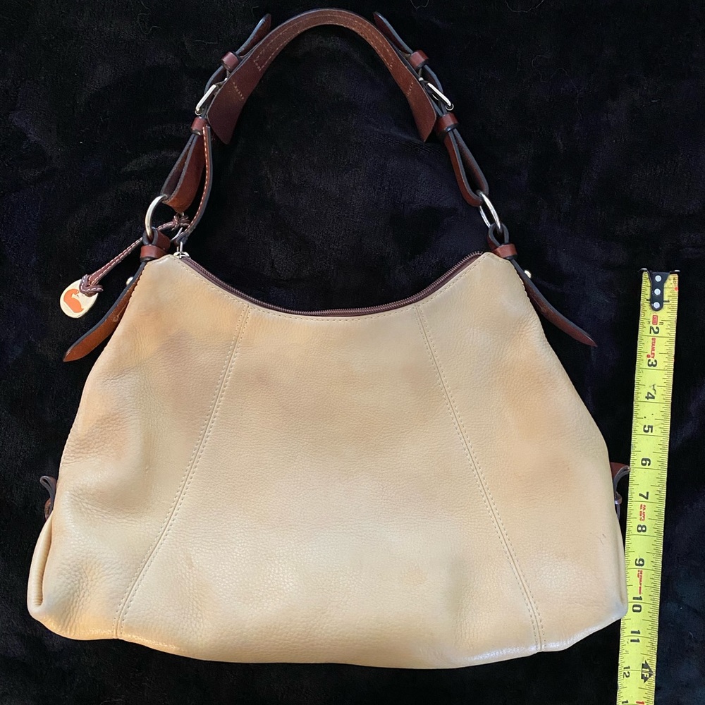 Dooney and Bourke bag. Soft tan/golden color with red interior